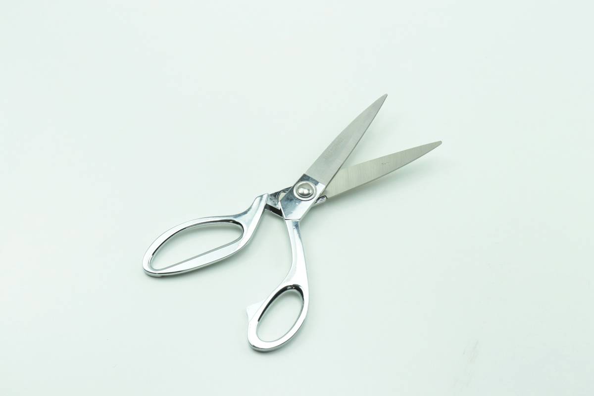 professional using brow grooming scissors on model under natural light