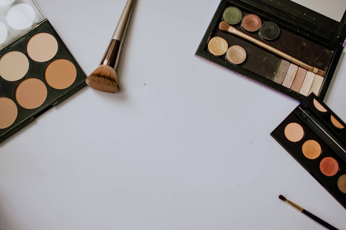 Close-up of stainless steel eyebrow grooming tool held against natural brows